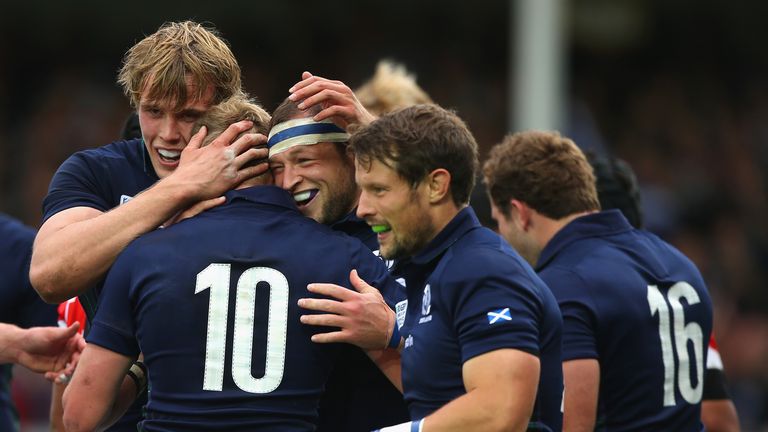 Finn Russell (#10) of Scotland is congratulated by team mates after scoring his teams fifth try against Japan