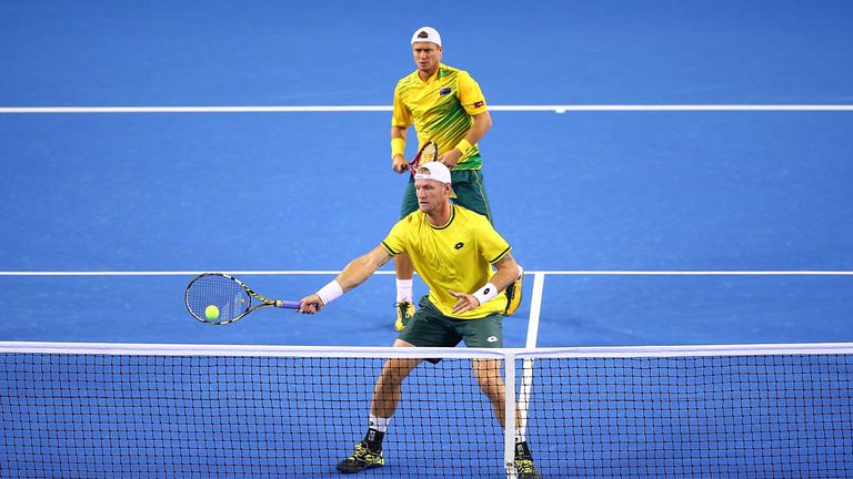 Samuel Groth of Australia hits a return as Lleyton Hewitt looks on during Day Two of the Davis Cup Semi Final match betw