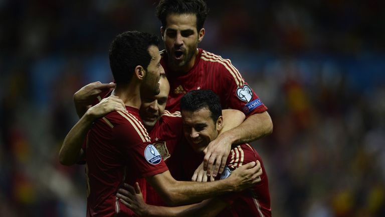 Andres Iniesta is embraced by teammates Pedro, Cesc Fabregas and Sergio Busquets after scoring during their Euro 2016 qualifier against Slovakia