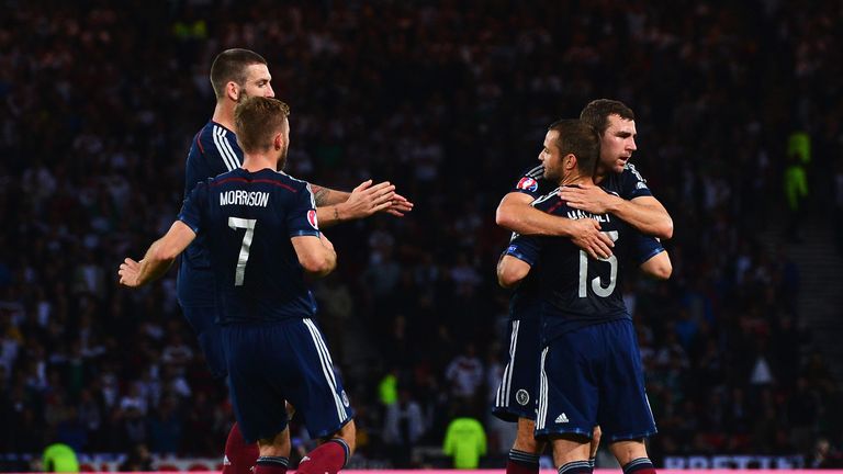 Shaun Maloney of Scotland celebrates the own goal scored by Mats Hummels of Germany 