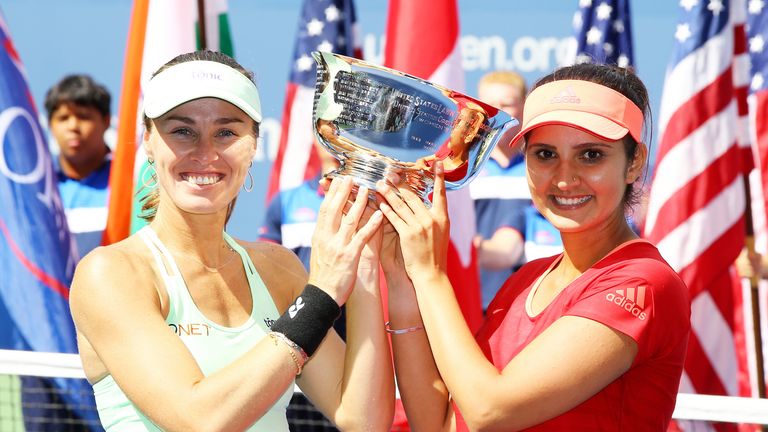 Martina Hingis (L) of Switzerland and Sania Mirza (R) of India celebrate with the US Open winner's trophy