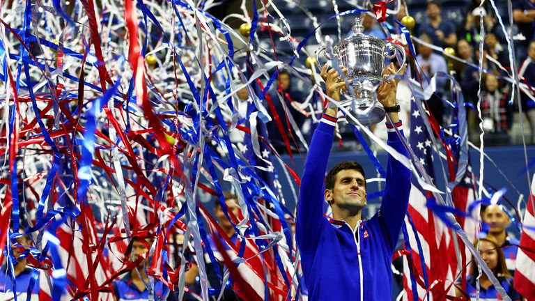 Novak Djokovic celebrates with the winner's trophy after defeating Roger Federer during their Men's final