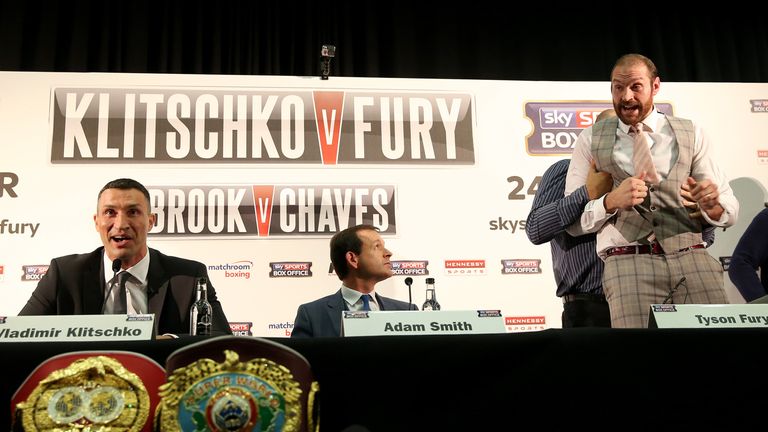 Tyson Fury (R) is restrained by father John after offering to fight Wladimir Klitschko at a London press conference