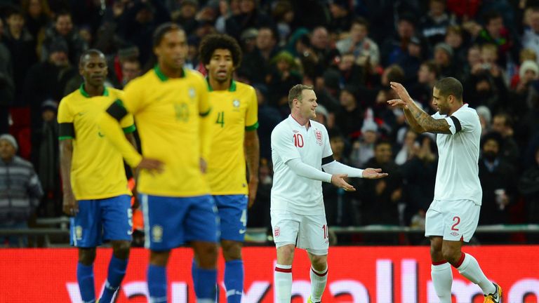 Wayne Rooney of England (back, L) is congratulated by team-mate Glen Johnson of England after he scored the opening goal against Brazil