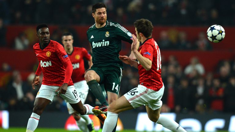 Real Madrid's Spanish midfielder Xabi Alonso (2R) crosses the ball between Manchester United's English striker Danny Welbeck (L) and Manchester United's En