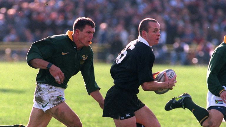 All Black full-back Christian Cullen is hounded by Springbok centre Andre Snyman during a TriNations clash