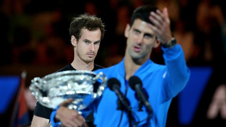 Andy Murray looks on as Novak Djokovic holds the Norman Brookes Challenge Cup 