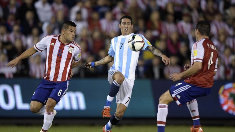 Paraguay's Pablo Cesar Aguilar (4) and his teammate Miguel Angel Samudio (L) vie for the ball with Argentina's forward Angel Di Maria 