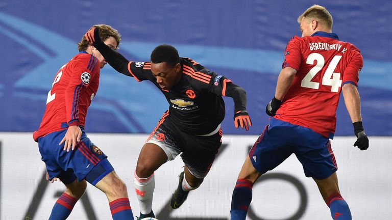 CSKA Moscow's Mario Fernandes (L) and Vasily Berezutskiy (R) vie for the ball with Manchester United's Anthony Martial