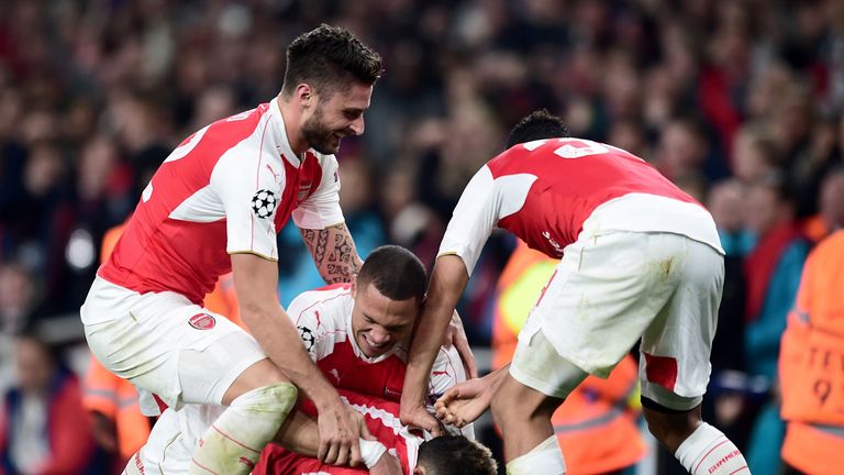 Arsenal's Mesut Ozil is mobbed by team-mates 