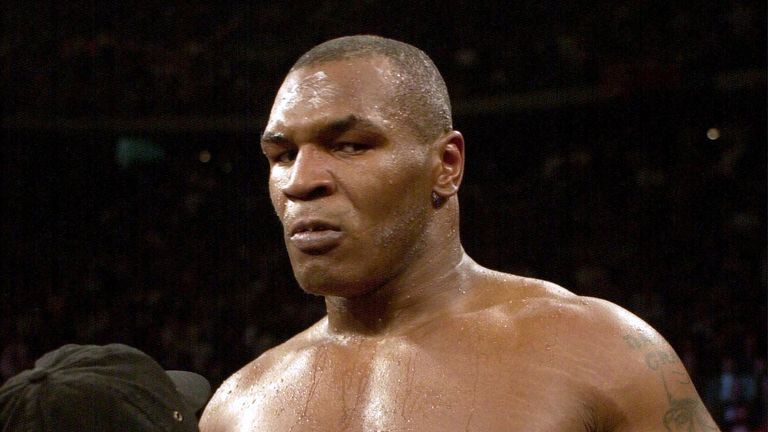 Heavyweight boxer Mike Tyson of the United States is raised in the air after Andrew Golota of Poland quit after the second round at the Palace of Auburn Hi