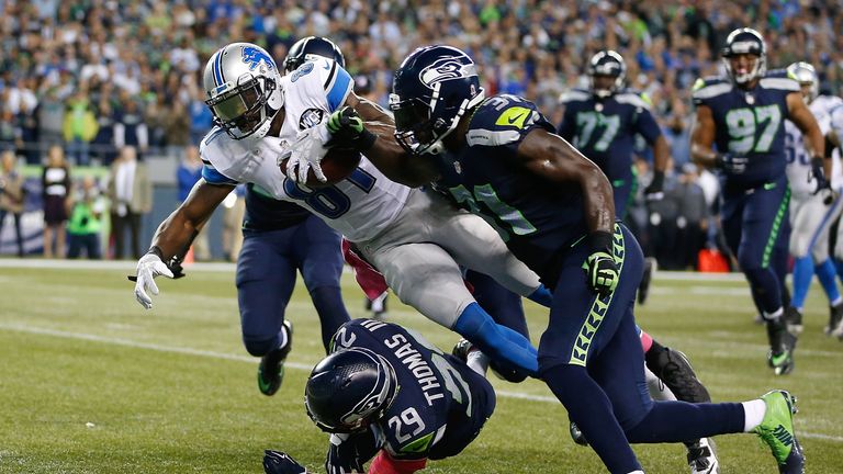 Kam Chancellor (R) punches the ball from Calvin Johnson's grasp as he dives for the endzone