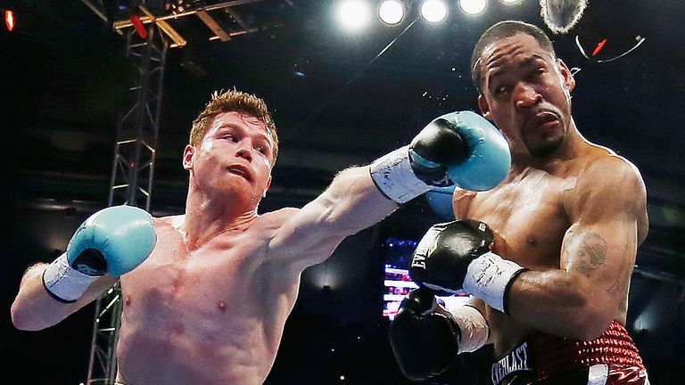 Canelo Alvarez of Mexico (L) delivers a punch to James Kirkland during their super welterweight bout at Minute Maid Park on May 9, 2