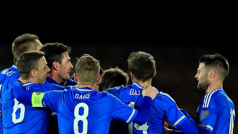 Craig Cathcart of Northern Ireland is mobbed after scoring the opening goal