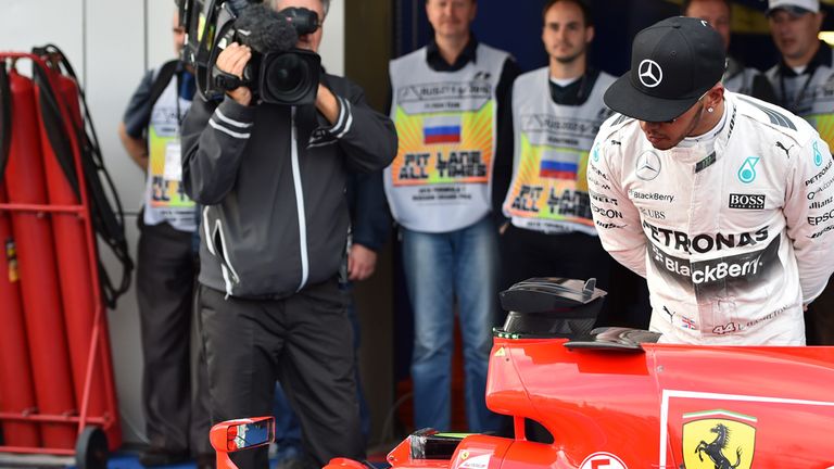 Lewis Hamilton checks out Sebastian Vettel's Ferrari after qualifying