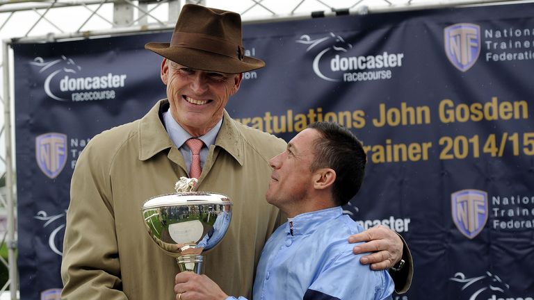 Trainer John Gosden receives the Trainers' Championship trophy from jockey Frankie Dettori.