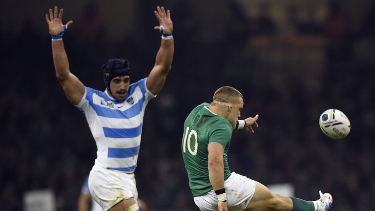 Ireland's fly half Ian Madigan (R) kicks the ball