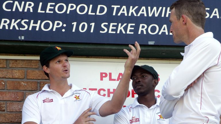 Zimbabwe's Mark Vermeulen (L) speaks to teammates Regis Chakabva (C) and Sean Williams (R) 