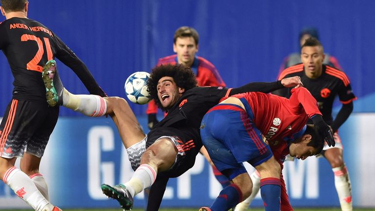 Manchester United's Marouane Fellaini (C) vies for the ball with CSKA Moscow's Alan Dzagoev (R)