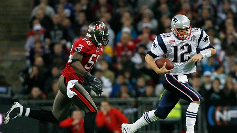 New England Patriots' Tom Brady (R) vies with Tampa Bay Buccaneers' Quincy Black (L) during their NFL International Series game against Tampa Bay Buccaneer