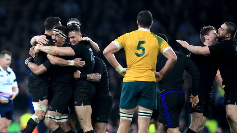 New Zealand players celebrate victory as Australia's Rob Simmons (centre) stands dejected during the Rugby World Cup Final at Twickenham, London.