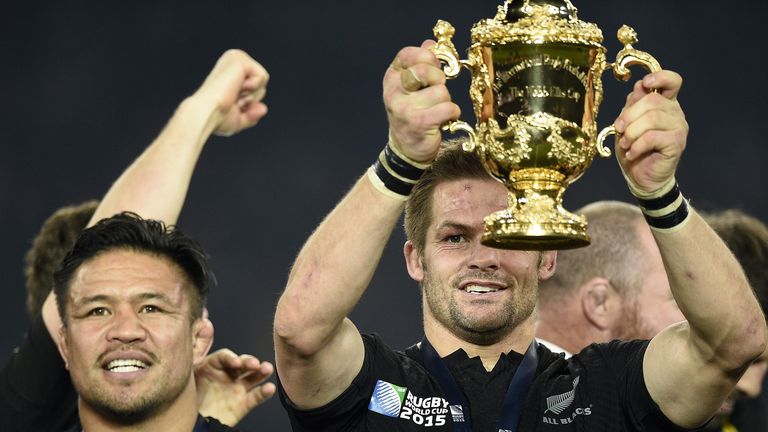 New Zealand's flanker and captain Richie McCaw (R) holds the Webb Ellis Cup 