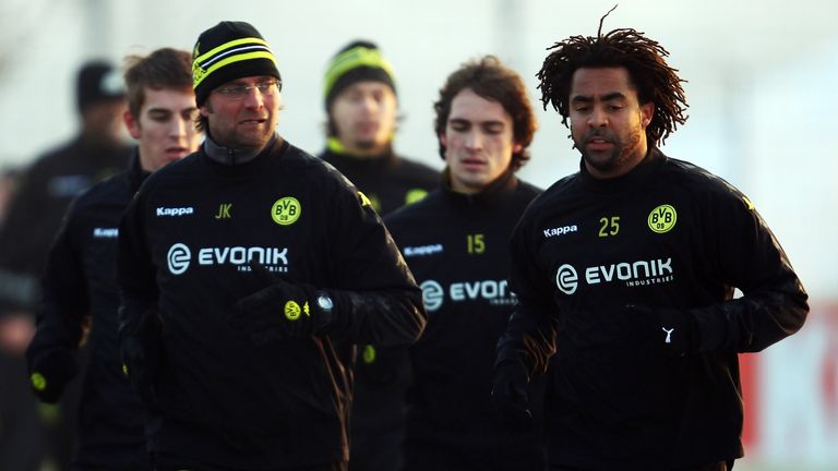 Patrick Owomoyela jogs next to former Borussia Dortmund manager Jurgen Klopp