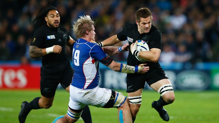 Richie McCaw of the New Zealand All Blacks is tackled by Renaldo Bothma of Namibia