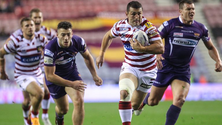 Wigan's Ben Flower escapes the tackle of Huddersfield's Jake Connor.