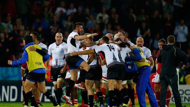 The Romania players celebrate their victory over Canada