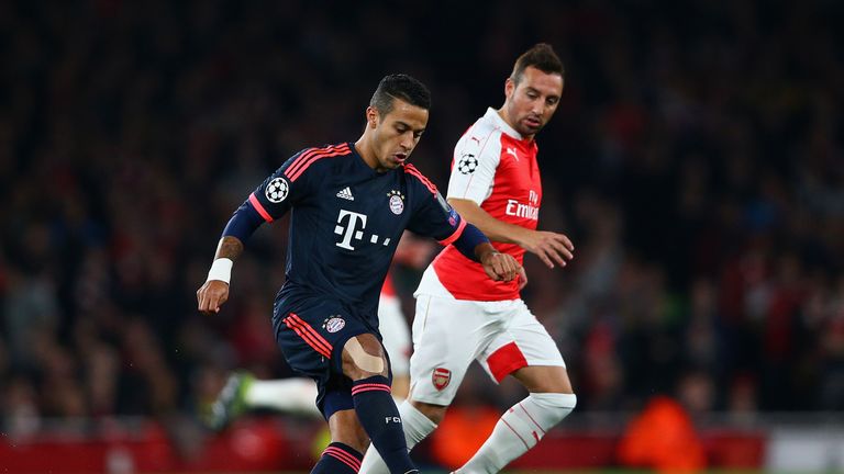 Thiago Alcantara of Bayern Munich is watched by Santi Cazorla of Arsenal
