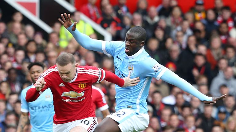 Wayne Rooney tussles with  Yaya Toure during the Manchester derby at Old Trafford