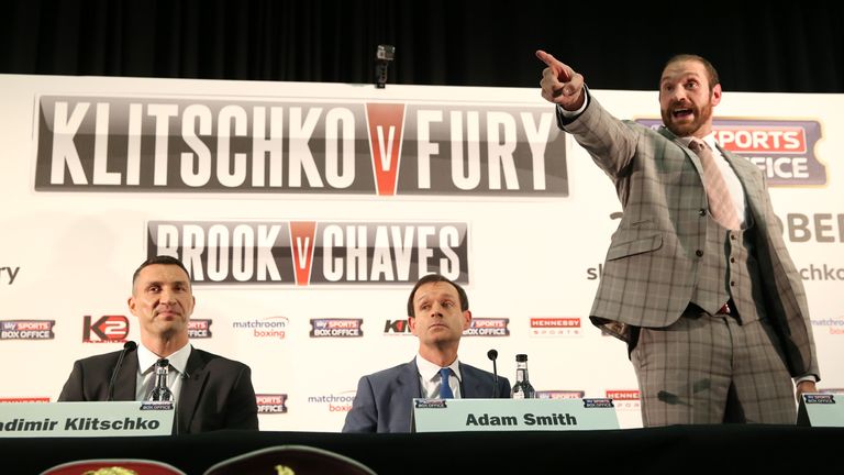 Tyson Fury (right) gestures to a member of the audience as Wladimir Klitschko (left) looks on