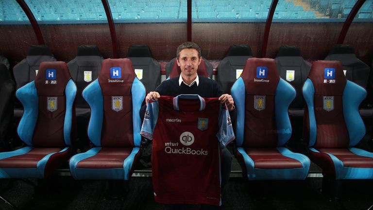 New Aston Villa manager Remi Garde poses in the dugout with a club shirt