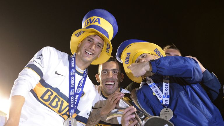 Boca Juniors' footballers (L-R) Rodrigo Betancur, Carlos Tevez and goalkeeper Agustin Orion celebrate with the trophy