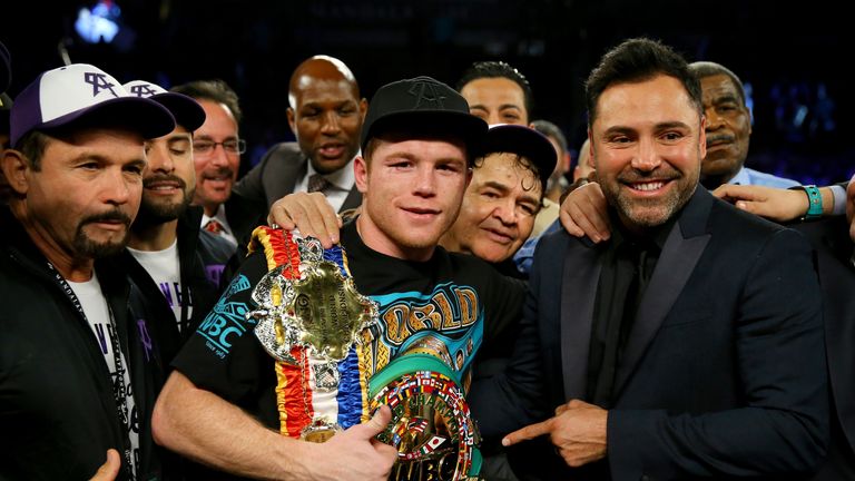 Canelo Alvarez celebrates with promoter Oscar De La Hoya after defeating Miguel Cotto by unanimous decision in their middleweight fight in Las Vegas