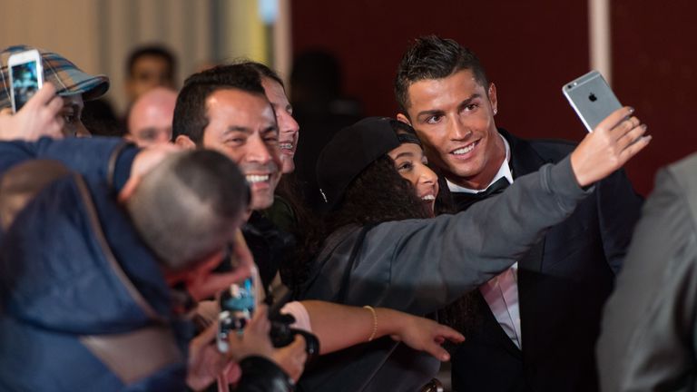 Cristiano Ronaldo takes a selfie with a fan at the premiere.