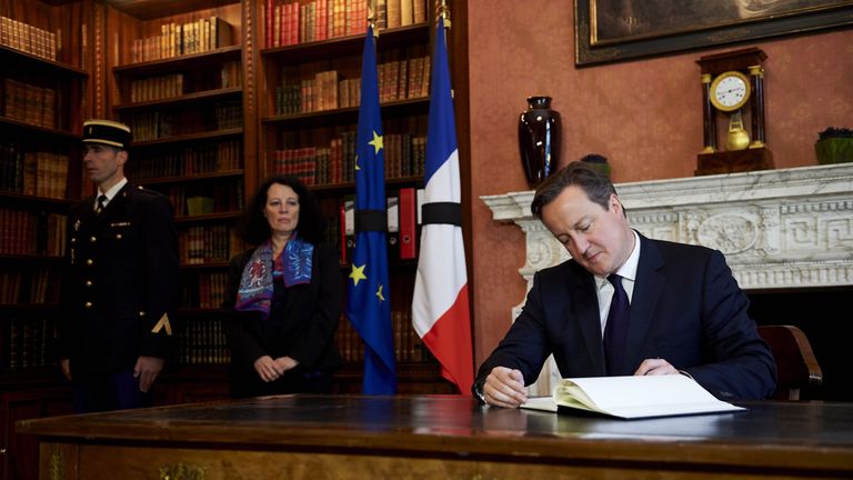 Prime Minister David Cameron signs a book of condolence at the French Ambassador's residence in London 
