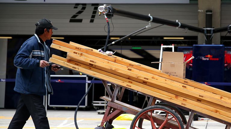 F1 in the slowlane: A workman pushes equipment through the pitlane ahead of the Chinese GP - Picture by Dan Istitene, Getty Images