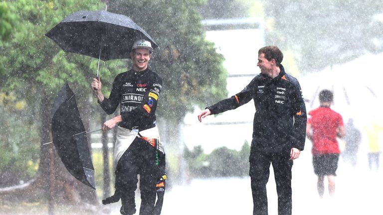 In the elements: Nico Hulkenberg  grabs the umbrella of Force India press officier Will Hings - Picture by Sutton Images