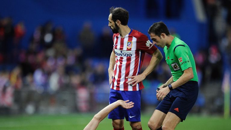 Tiago Mendes of Atletico Madrid lies injured beside Juan fran during the La Liga match