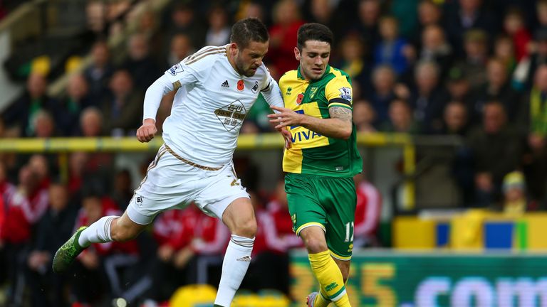 Gylfi Sigurdsson (L) of Swansea City and Robbie Brady of Norwich City compete for the ball