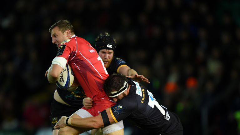 Hadleigh Parkes of Scarlets is tackled by Tom Wood