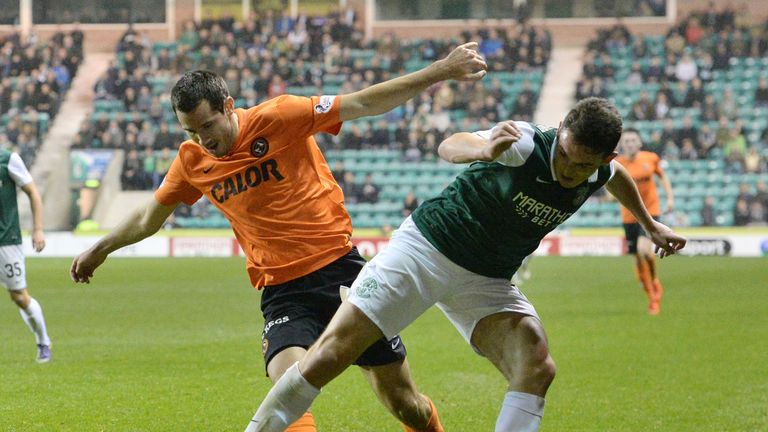 Dundee United captain Ryan McGowan battles for the ball against Hibernian's John McGinn