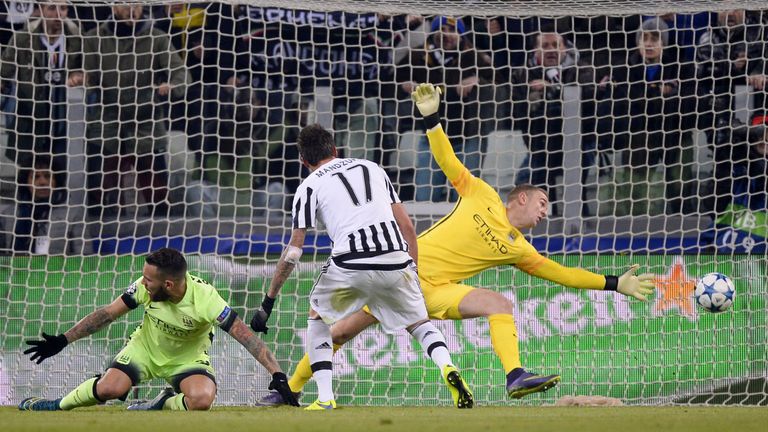 Juventus forward Mario Mandzukic (C) scores against Manchester City goalkeeper Joe Hart