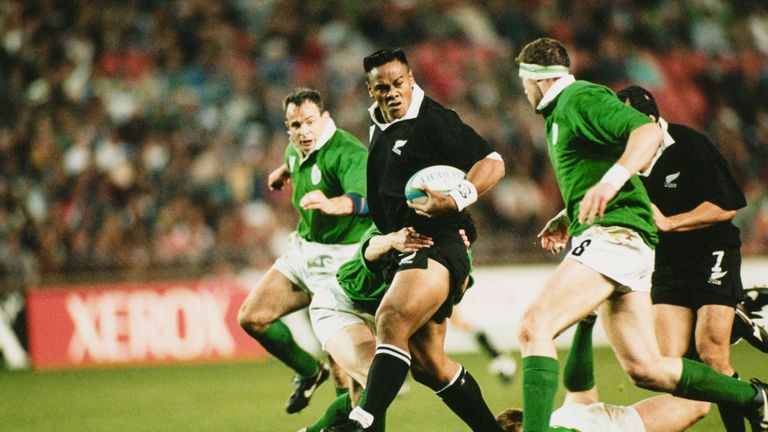 Jonah Lomu looks for support as he is tackled by Ireland's Eric Elwood