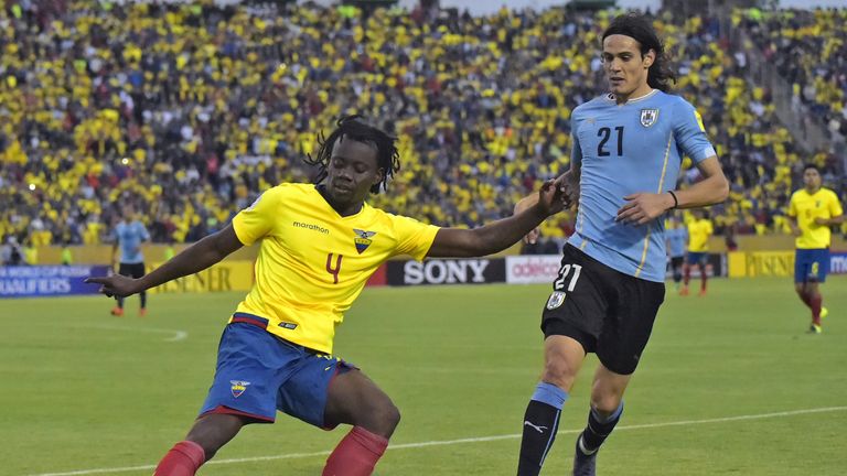 Ecuador's Juan Carlos Paredes (L) vies for the ball with Uruguay's Edinson Cavani 