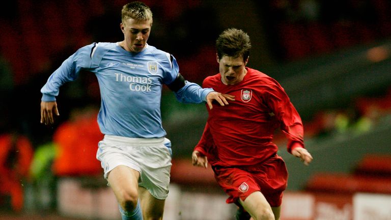 Michael Johnson of Man City (l) holds off an opponent.