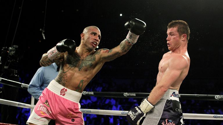 Miguel Cotto of Puerto Rico (L) swings wide against Saul 'Canelo' Alvarez of  Mexico (R)