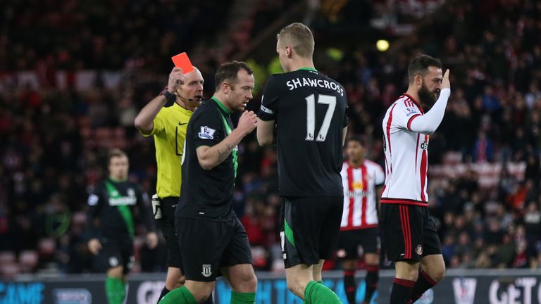 Referee Mike Dean shows Stoke's Ryan Shawcross (second right) a red card